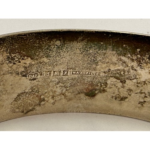 563 - A small group of mixed jewellery including a broad hinge-opening silver bangle by Owen Powell, Birmi... 