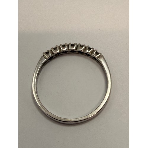  A platinum half-hoop ring, claw-set with seven round white stones, stamped 950 and hallmarked London... 