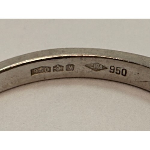  A platinum half-hoop ring, claw-set with seven round white stones, stamped 950 and hallmarked London... 