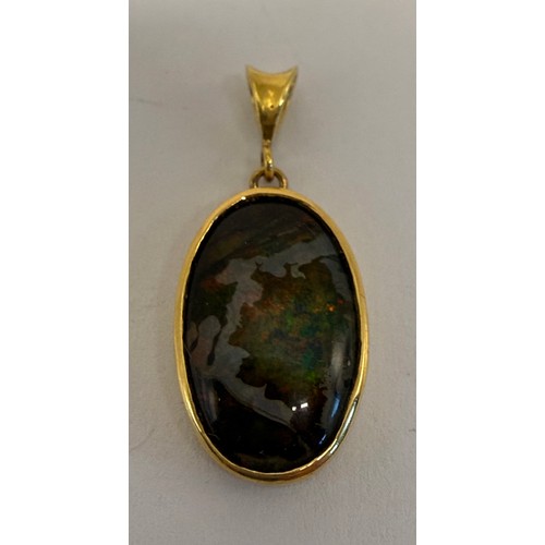  A black opal pendant, the oval stone collet set in gold, with open back, hallmarked (rubbed). 17mm (... 