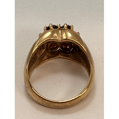  A large 9 carat gold garnet cluster ring, the seven claw-set graduated round stones as a flowerhead ... 
