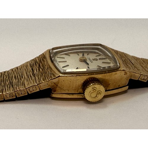  A lady's 9 carat gold wristwatch to an articulated textured bracelet strap, the square dial signed O... 