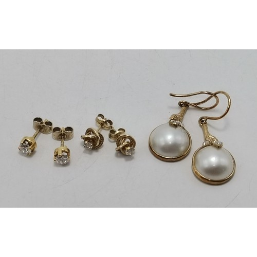 587 - Three pairs of gold-mounted earrings comprising a pair of diamond studs, hallmarked 750; a pair of k... 