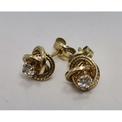587 - Three pairs of gold-mounted earrings comprising a pair of diamond studs, hallmarked 750; a pair of k... 