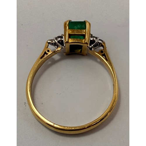  An 18 carat gold gemstone ring, claw-set with a central emerald-cut green stone flanked by a cluster... 