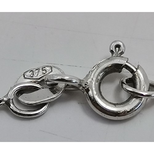 601 - A white gold fine trace chain necklace, stamped 375 and 9k to clasp, hung with a white metal-mounted... 