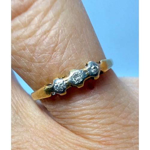 An 18 carat gold and platinum three-stone ring, the carved and pierced gallery mount illusion-set wi... 