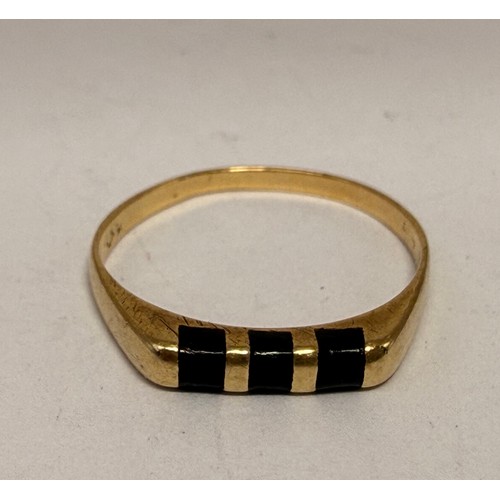 608 - A gold and onyx ring, the flat-top mount set with three black bands, (marks rubbed). Ring size L1/2,... 