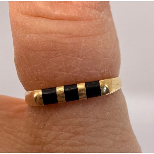 608 - A gold and onyx ring, the flat-top mount set with three black bands, (marks rubbed). Ring size L1/2,... 