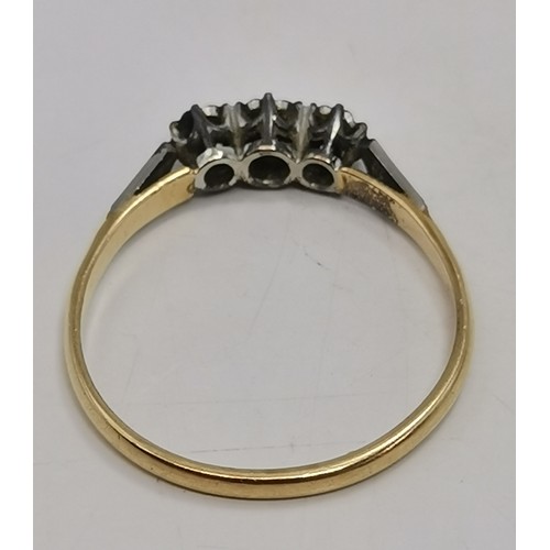  A three-stone ring, illusion-set with graduated round diamonds in a raised openwork mount with carve... 