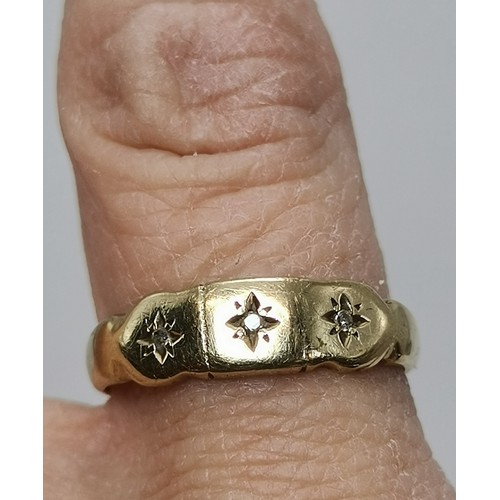  A three-stone ring, illusion-set with graduated round diamonds in a raised openwork mount with carve... 