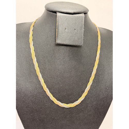  An Italian tri-coloured gold jewellery suite comprising a flat link braided necklace and bracelet, t... 