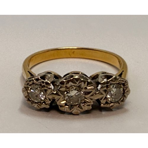 618 - A diamond three-stone ring, the round brilliant cut stones illusion-set to graduated white metal cor... 