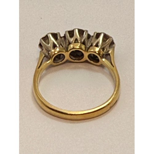 618 - A diamond three-stone ring, the round brilliant cut stones illusion-set to graduated white metal cor... 