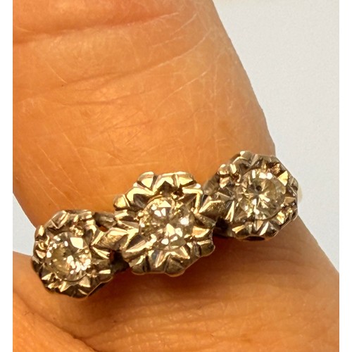 618 - A diamond three-stone ring, the round brilliant cut stones illusion-set to graduated white metal cor... 