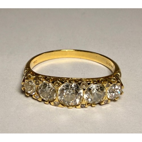 622 - An 18 carat gold five-stone ring, the graduated round white stones set with four pairs of accent sto... 