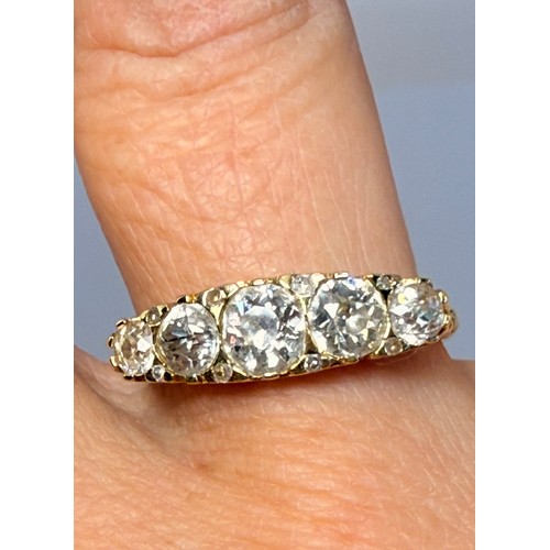 622 - An 18 carat gold five-stone ring, the graduated round white stones set with four pairs of accent sto... 