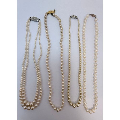628 - Four assorted pearl necklaces, one a graduated double-string, one with a 9 carat gold clasp. (4)