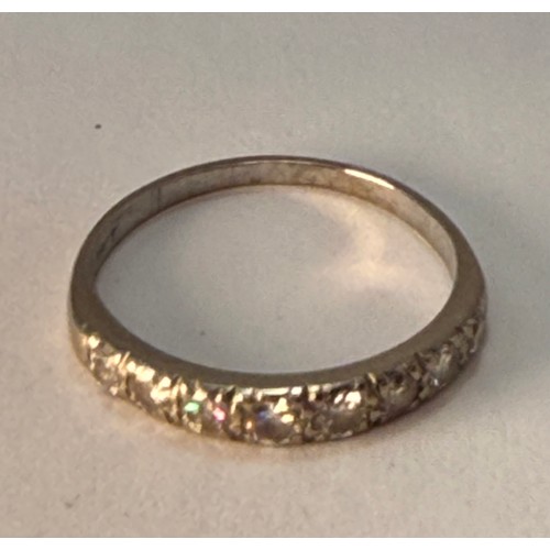  A white gold half hoop ring, set with eight graduated round white stones, stamped '18CT'. Ring size ... 