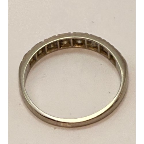  A white gold half hoop ring, set with eight graduated round white stones, stamped '18CT'. Ring size ... 