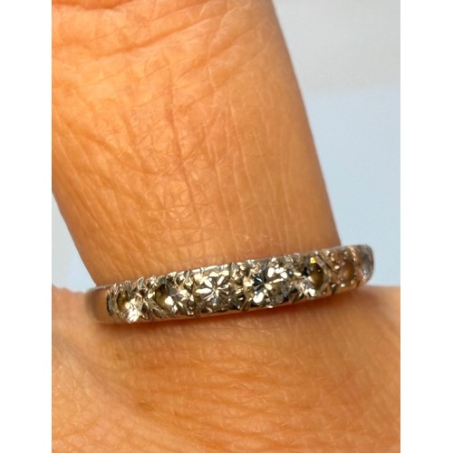  A white gold half hoop ring, set with eight graduated round white stones, stamped '18CT'. Ring size ... 