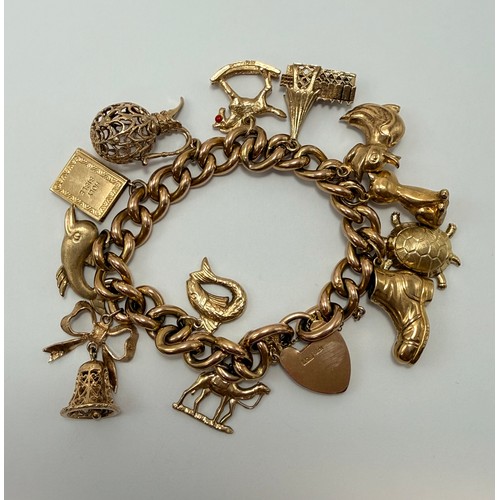  A 9 carat gold charm bracelet with heart padlock clasp, hung with twelve assorted charms, the curb l... 