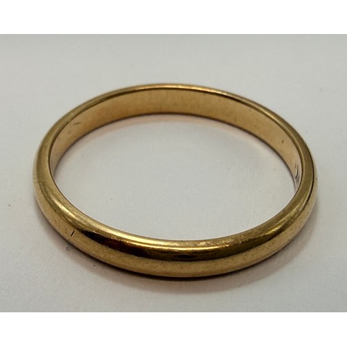 642 - A 9 carat gold wedding band, hallmarked Birmingham 1988, ring size S1/2; together with a three-stone... 