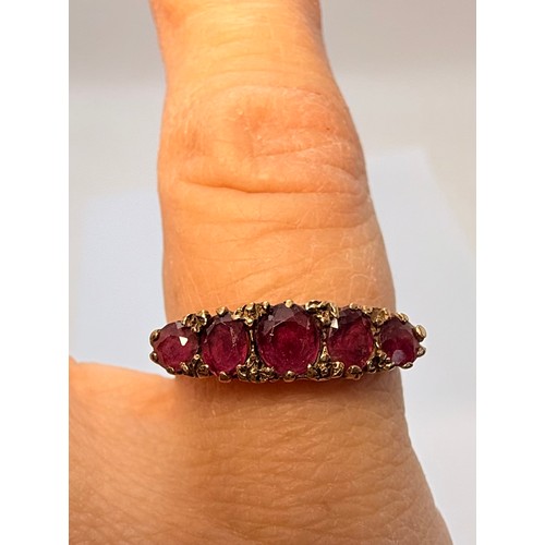  A 9 carat gold five-stone ring, the graduated round pink stones set to a carved and pierced gallery ... 