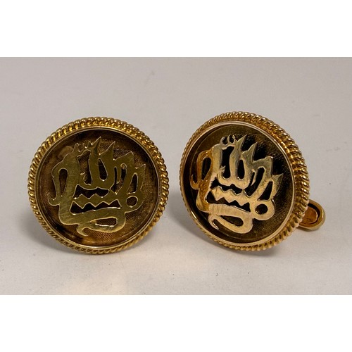  A pair of yellow metal cufflinks, circular with cut-out Arabic character script within a rope-twist ... 