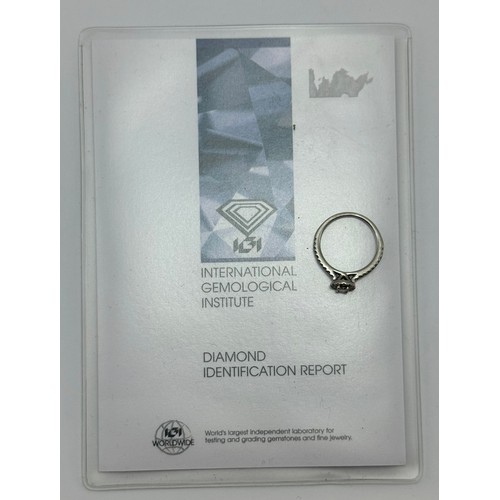  A platinum diamond engagement ring, the central oval brilliant cut stone enclosed by a halo of round... 