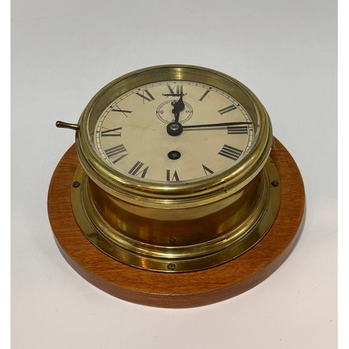 2 - Early to mid 20th century brass bulkhead ships clock.  It features a classic round dial with roman n... 