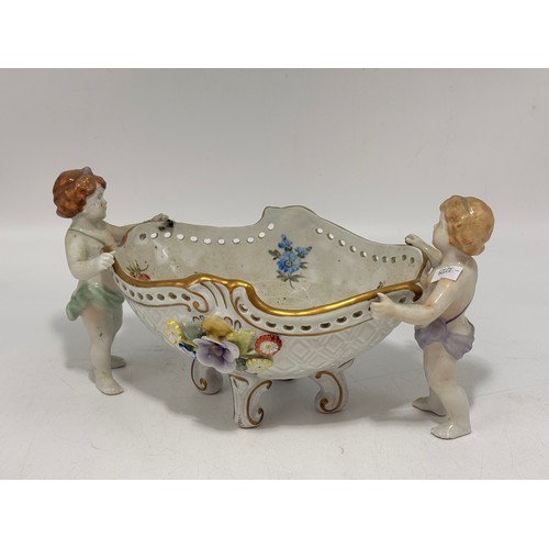 311 - Three items comprising a Von Schierholz porcelain centrepiece with two putti elaborately decorated w... 