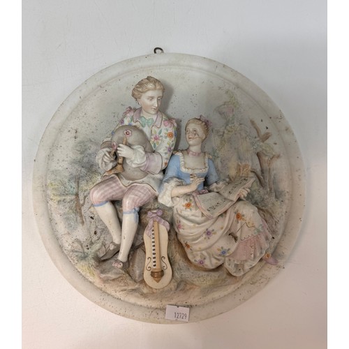 320 - Three bisque porcelain wall plaques featuring high-relief scenes of courting couples.  D 25 cm.