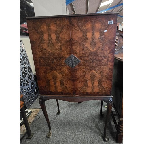 805 - A vintage Queen Anne style burr walnut cabinet raised on carved cabriole legs joined by a shaped apr... 