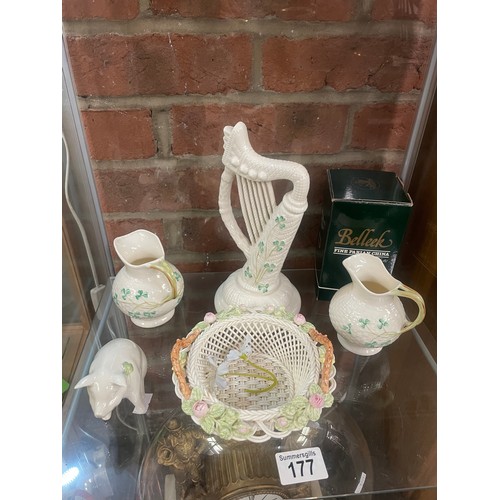 177 - A collection of Belleek comprising a harp, two jugs, a pig and a basket, all with boxes