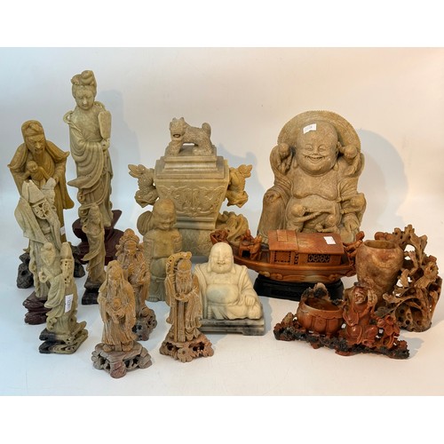 217 - A collection of oriental soapstone carvings including figural models, three Buddha figures, a boat, ... 