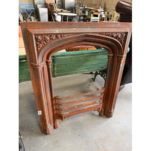 939 - A cast iron fire surround with foliate spandrels over pillar uprights, with incorporated grille fron... 