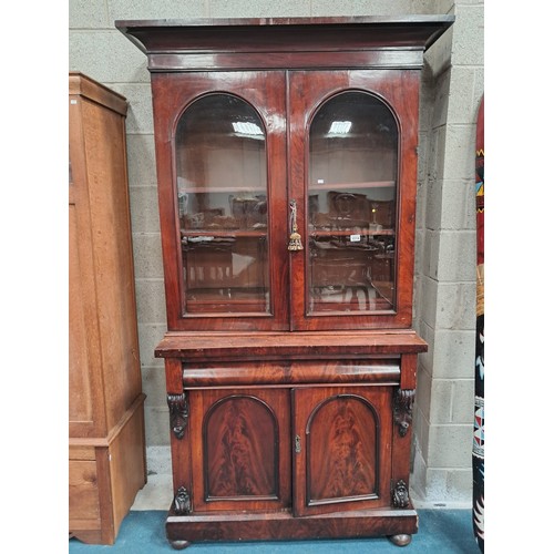 1014 - Victorian Mahogany glazed cupboard bookcase with arched doors and mounted cornice.  Two shelves in b... 
