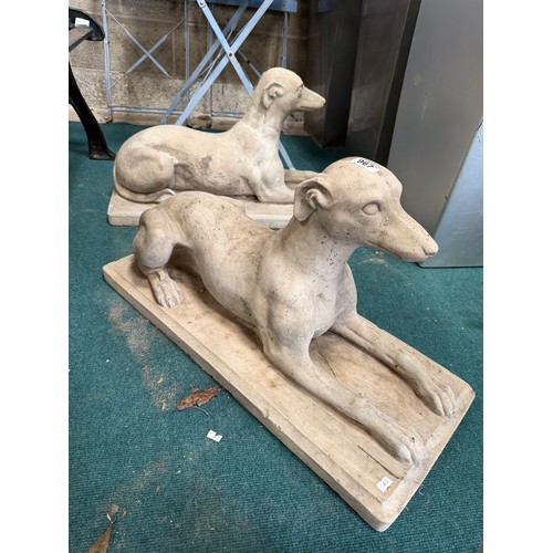 967 - A pair of composite stone dog sculptures, each modelled as a recumbent hound on a rectangular base. ... 