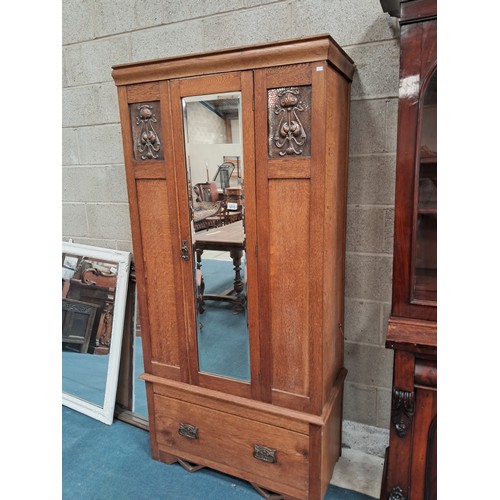 1015 - Arts and Crafts oak wardrobe with a single mirrored door and copper panels to either side.  One deep... 