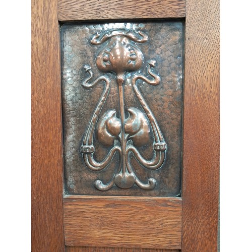 1015 - Arts and Crafts oak wardrobe with a single mirrored door and copper panels to either side.  One deep... 
