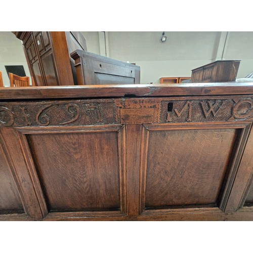 916 - An early English Oak panelled coffer with carved lunette frieze and 1697 and initials MW carved to f... 