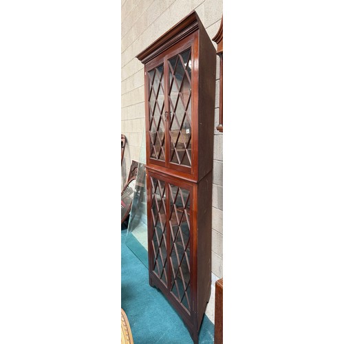 994 - A large repro mahogany double corner cabinet, with dentil cornice over astragal glazed pair of cupbo... 