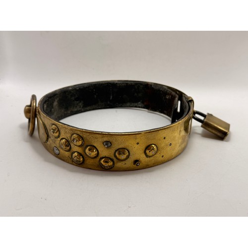 458 - A large 19th Century brass dog collar, adjustable, with applied domed studs, ring fixing and padlock... 