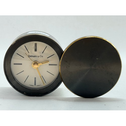 491 - A travel alarm clock, cylindrical metal with spin-off hinged cover, the dial signed Tiffany & Co, wi... 