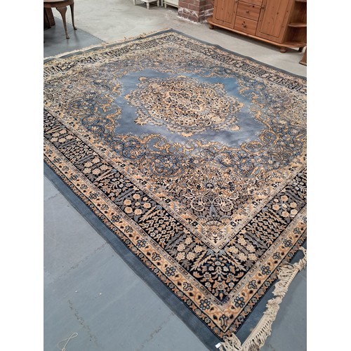 1019 - A large wool rug in blues, cream and gold with floral decorations. 4.2m x 2.8m