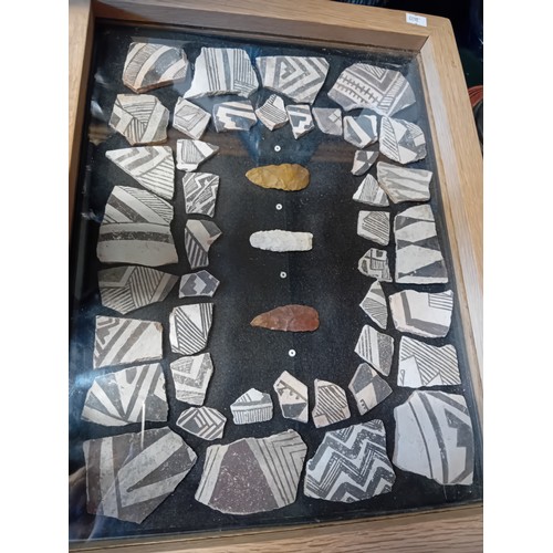 12 - A framed display containing Native American Anasazi pottery shards and some stones. H