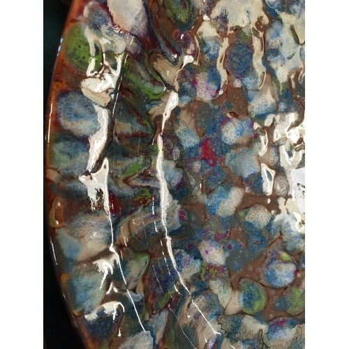 24 - Large contemporary studio pottery charger or shallow bowl.  The surface is glazed with a multi colou... 