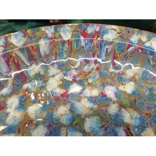 24 - Large contemporary studio pottery charger or shallow bowl.  The surface is glazed with a multi colou... 