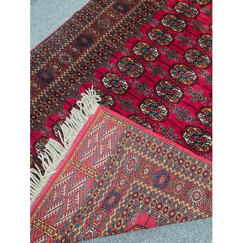 845 - A Hand knotted wool red Bokhara Rug featuring traditional repeating pattern in deep red and black 12... 
